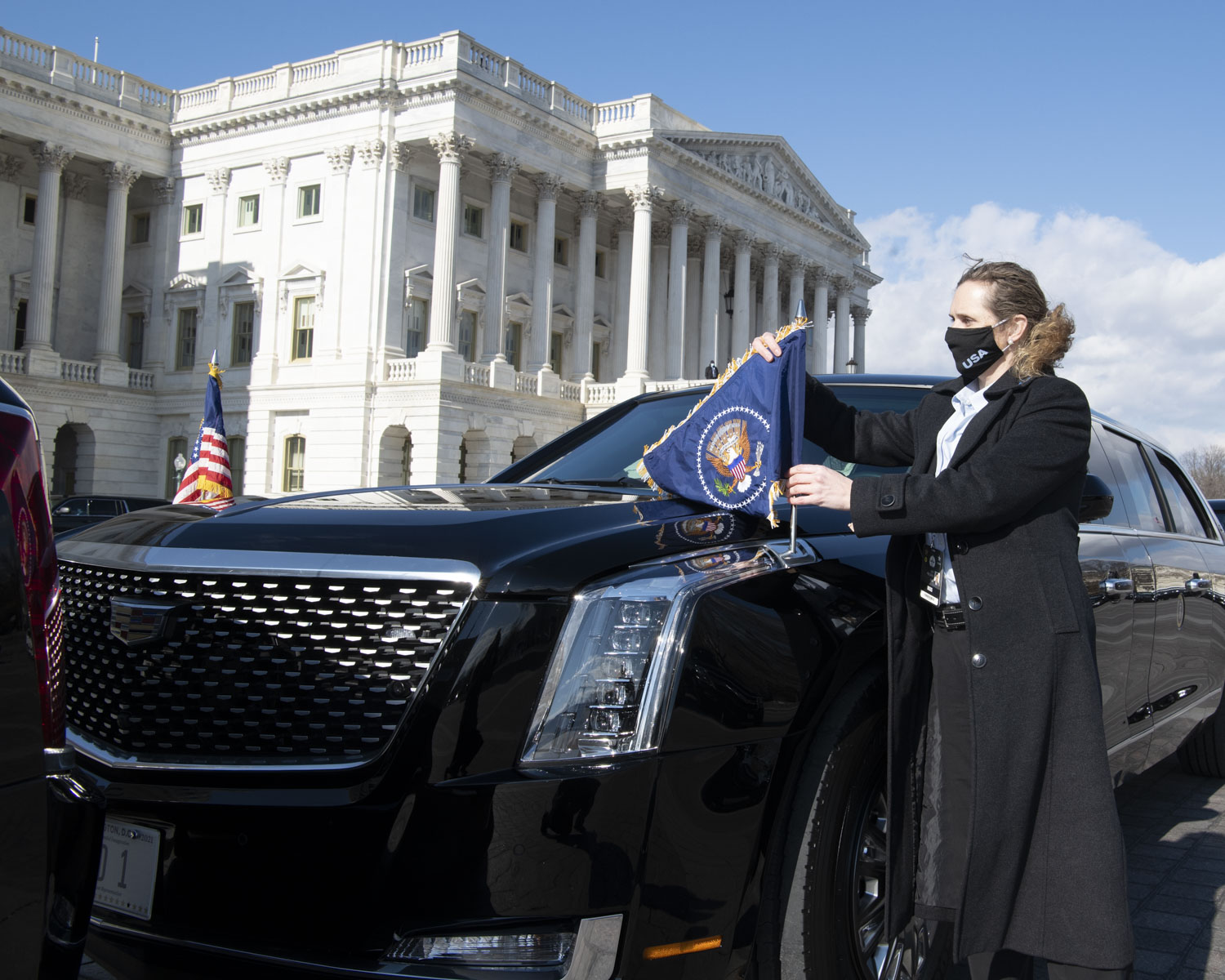 Secret Service Special Agent adjusting flag on a presidential vehicle