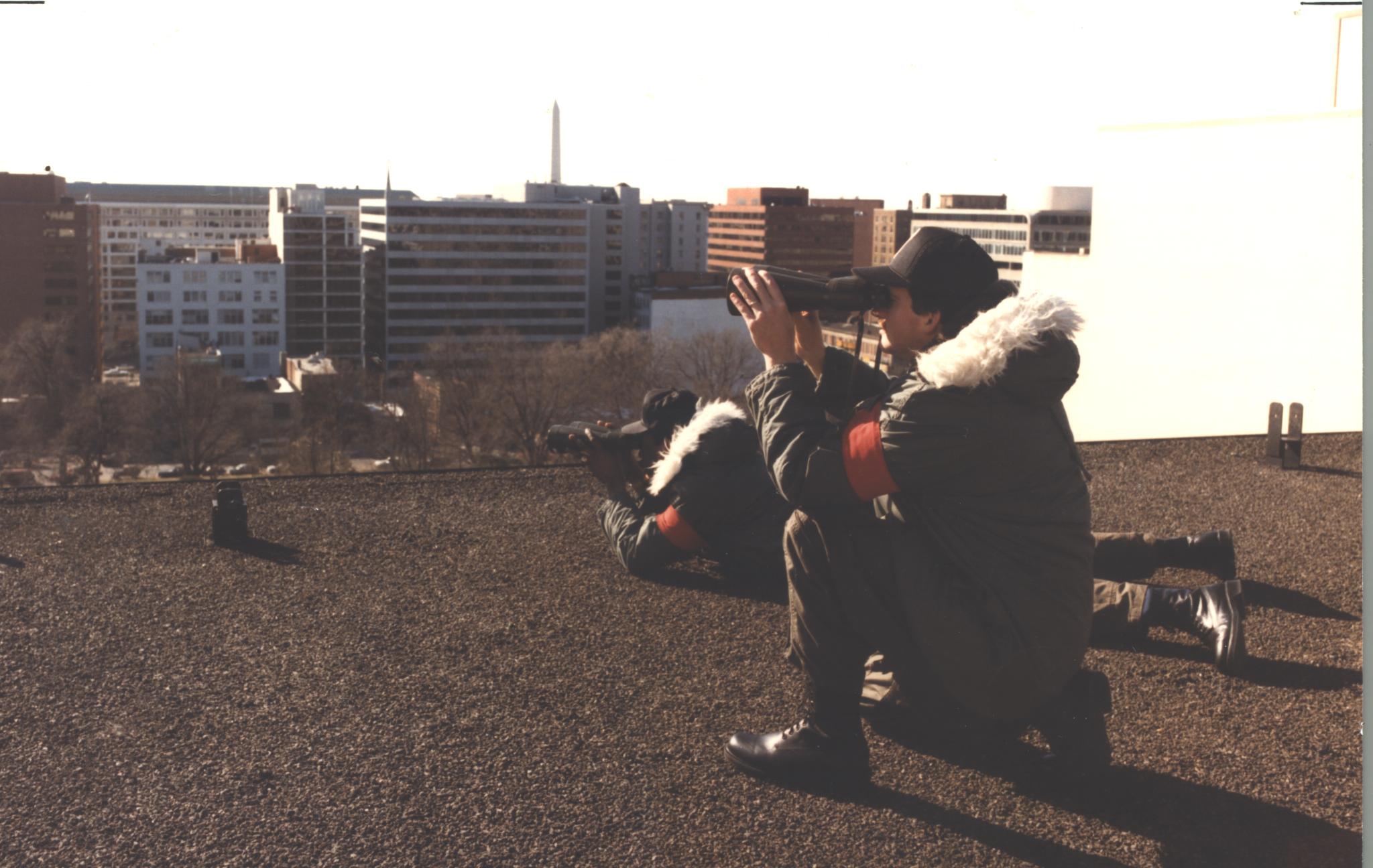 Two members of the Counter Sniper Team surveil their surroundings on a rood in the 1970s.