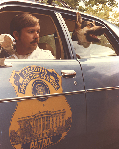 A Uniformed Division Officer and canine sit in a police cruiser in 1975.