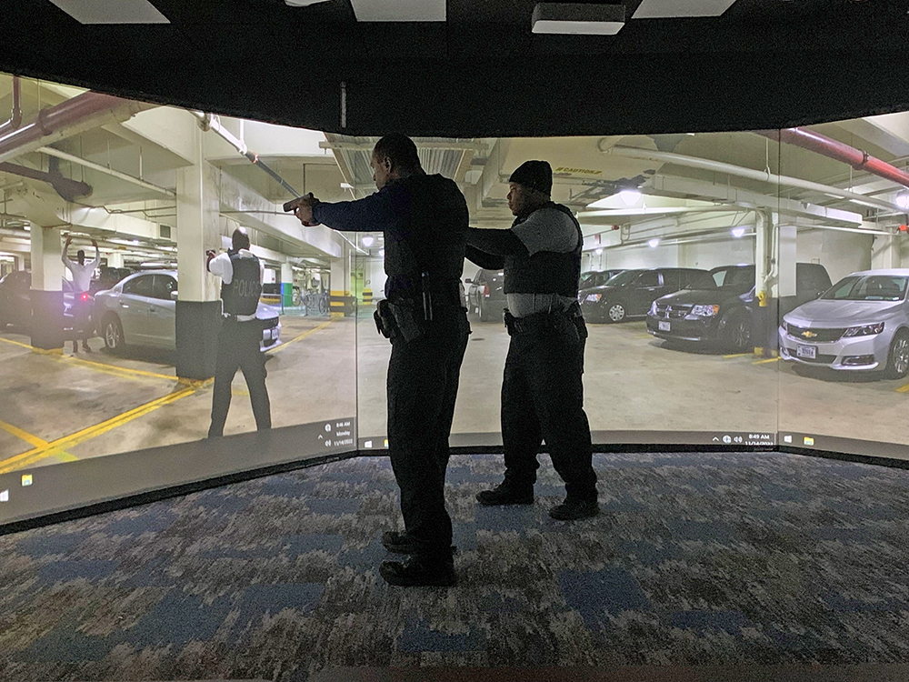 Two Uniformed Division Officers using a virtual training simulator.