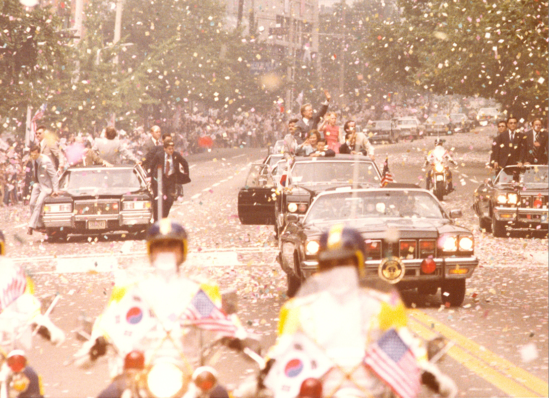  Special agents ride on the outside of limos as President Carter waves to the crowd in South Korea.