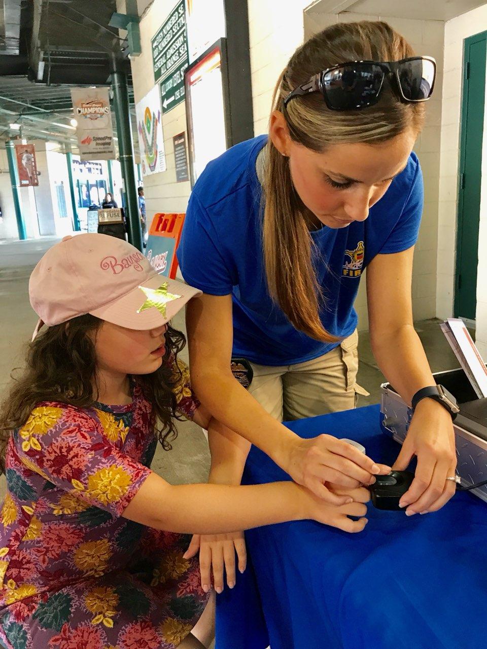 Special Agent Jaime Swears fingerprints a child during a NCMEC Operation Safe Kids event.
