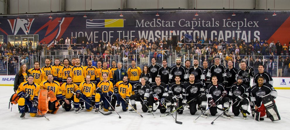 Secret Service and FBI hockey teams pose before their 2023 charity hockey game.