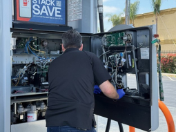 Investigators inspect the interior of a gas station pump looking for card skimmers.