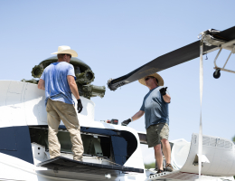 Workers install the helicopter blades onto the recently decommissioned VH-3D.